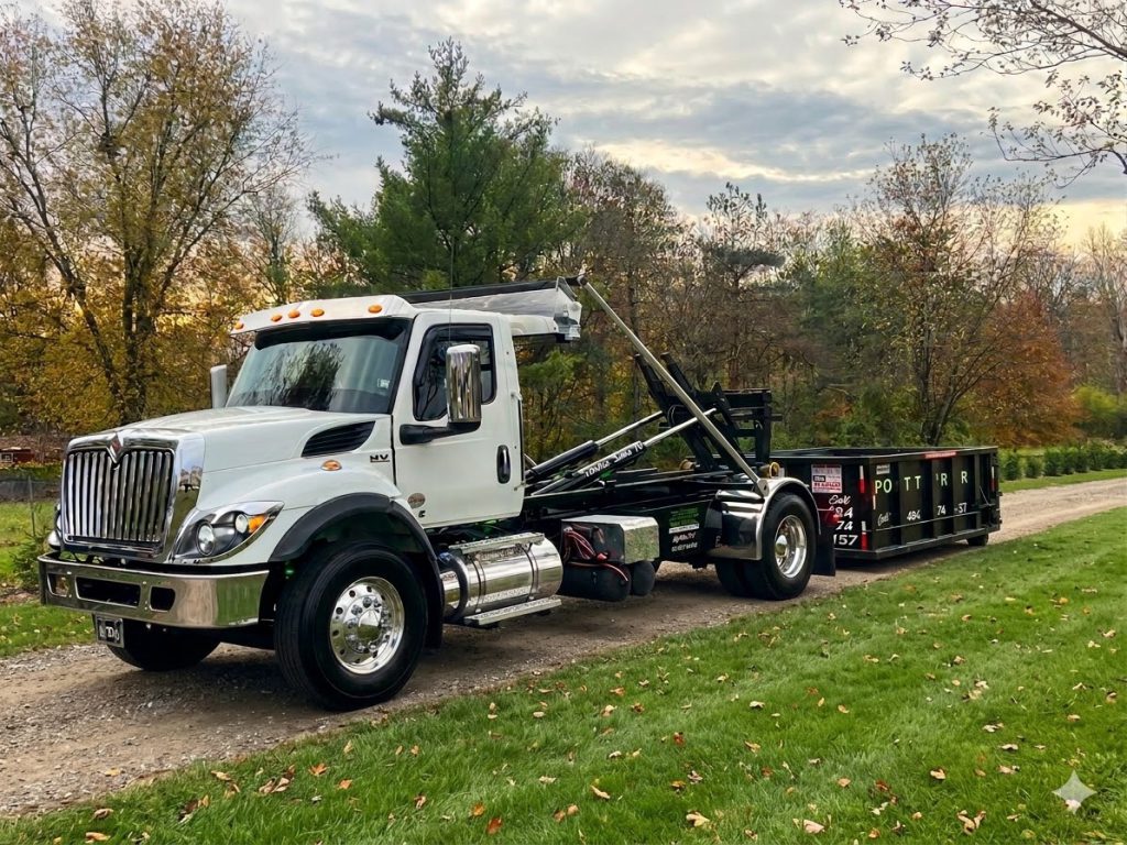 A Dotterer Disposal truck with a dumpster placed behind it