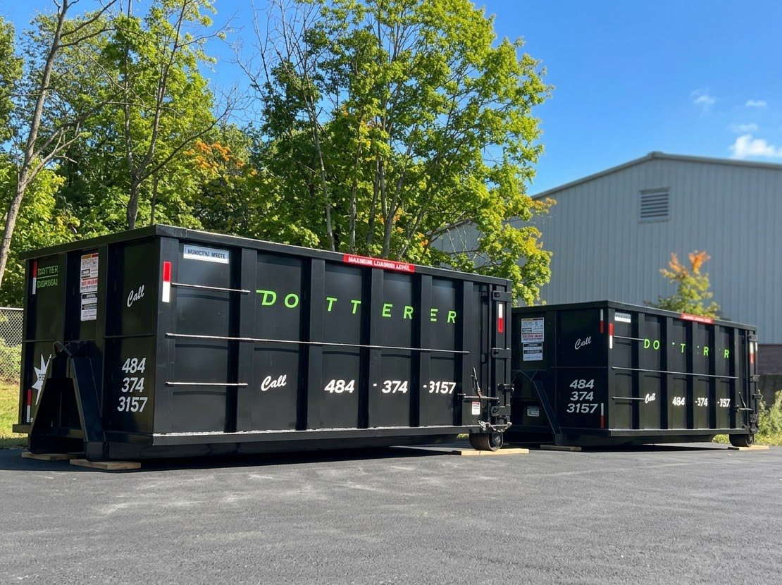 Two Dotterer Disposal dumpsters in front of a large building