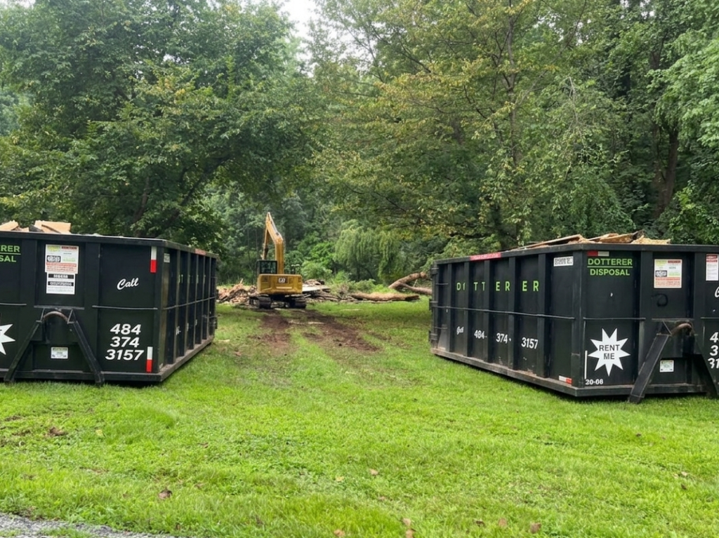 Two Dotterer Disposal dumpsters in front of a worksite