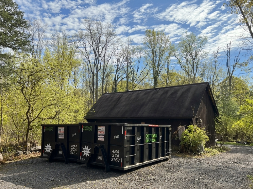 Two Dotterer Disposal dumpsters in front of a shed